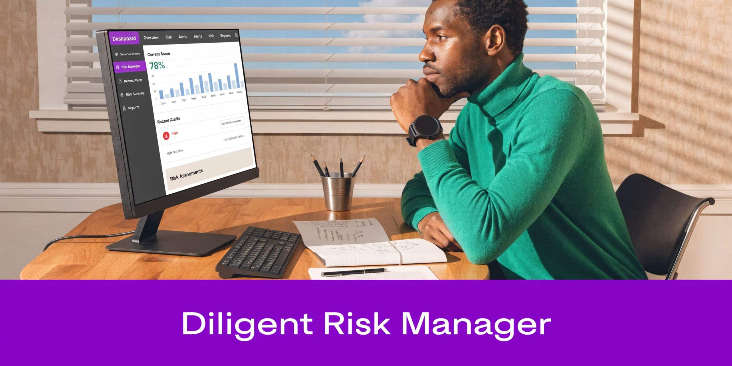 A professional man sitting at a desk reviewing risk management data on a computer screen in an office.