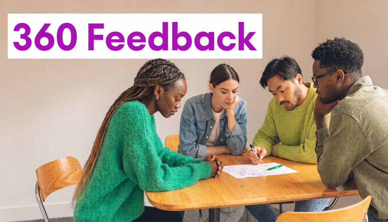 A diverse group of four colleagues collaboratively discussing feedback while looking at notes on a wooden table.