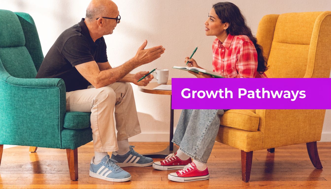 An older man and a young woman sitting in armchairs having a professional career development discussion.