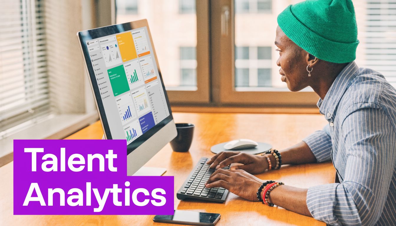 A person wearing a green beanie working on talent analytics software on a desktop computer monitor.